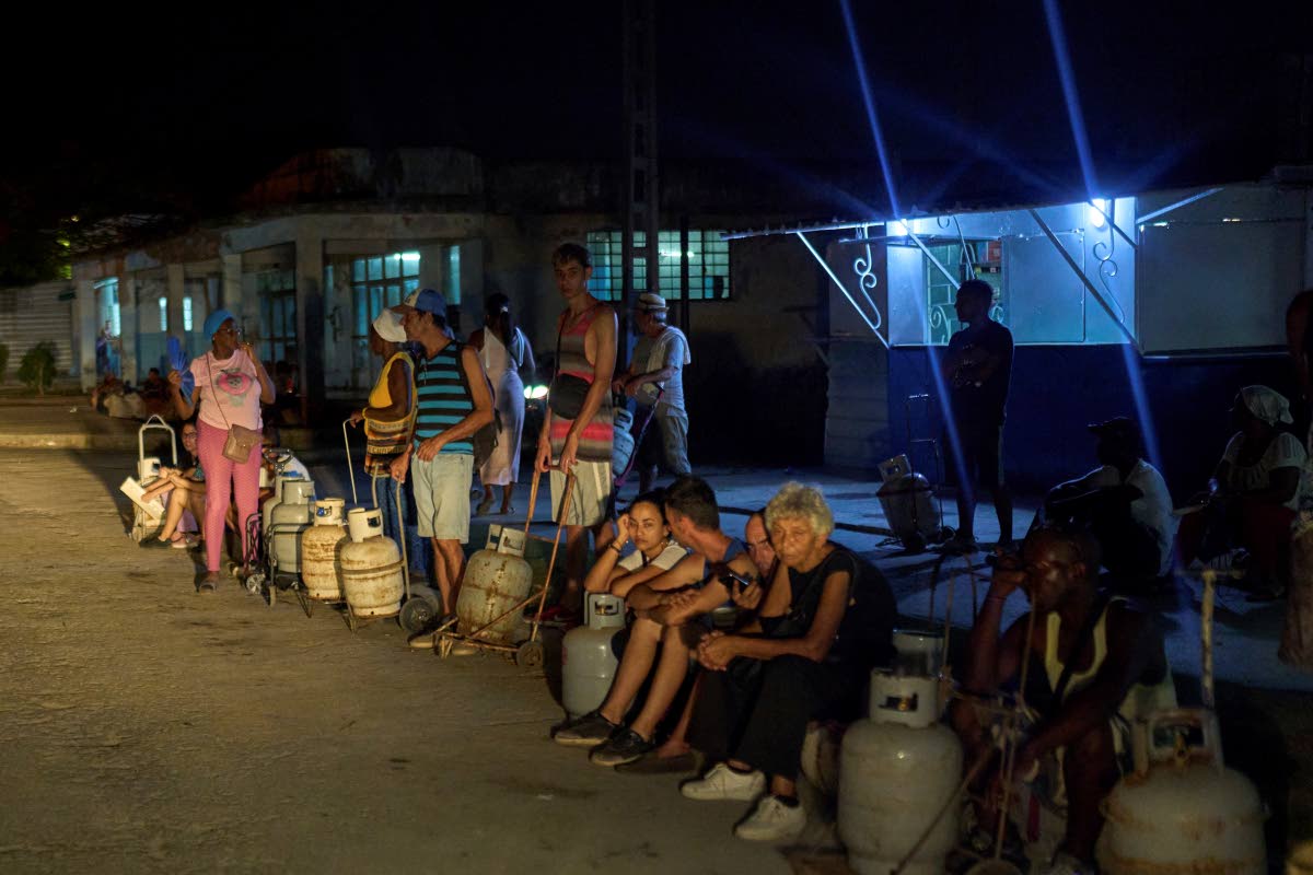 People wait to refill their cooking gas canisters in Alamar, Havana province, Cuba, late on Saturday, May 31, 2025. 
