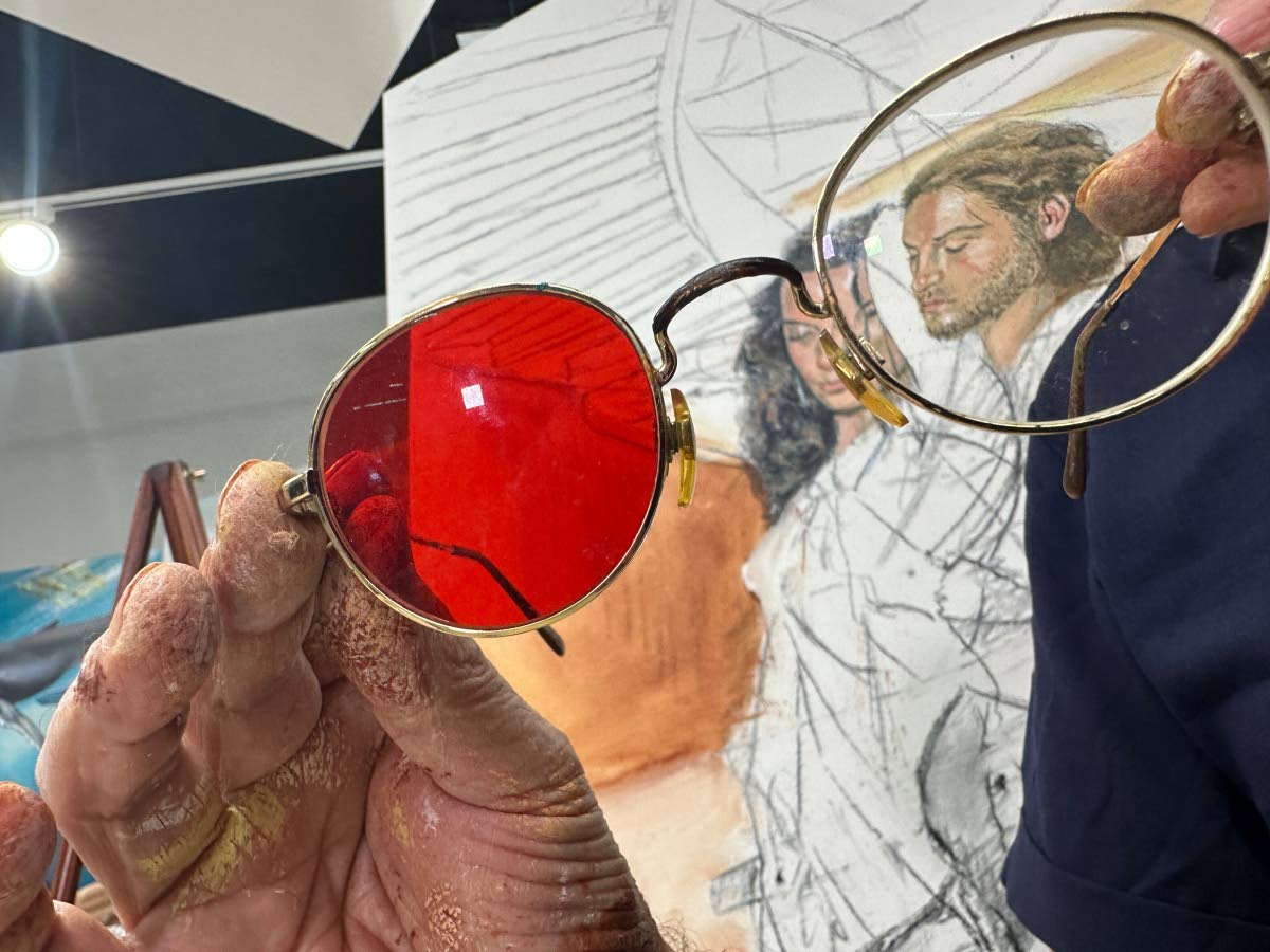 Fernando Dávila, a colour-blind painter, shows his glasses designed to help see colour.