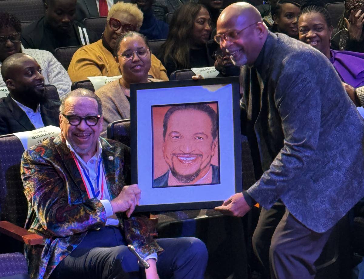 Richard Smallwood (left) is handed a portrait of himself during his 75th birthday celebration.