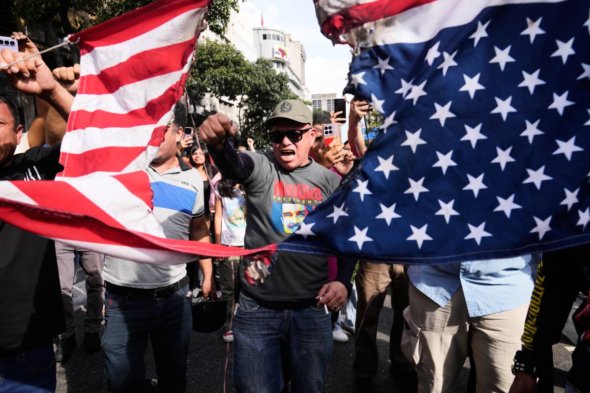 Government supporters rip an American flag in half during a protest in Caracas, Venezuela, Saturday, Jan. 3, 2026, after U.S. President Donald Trump announced that U.S. forces had captured President Nicolás Maduro and first lady Cilia Flores. 