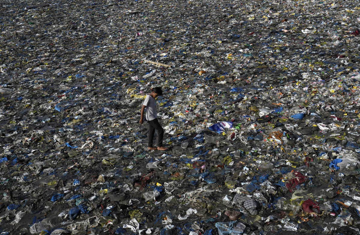 A boy walks on the plastic waste at the Badhwar Park beach on the Arabian Sea coast on World Environment Day in Mumbai, India, Monday, June 5, 2023.