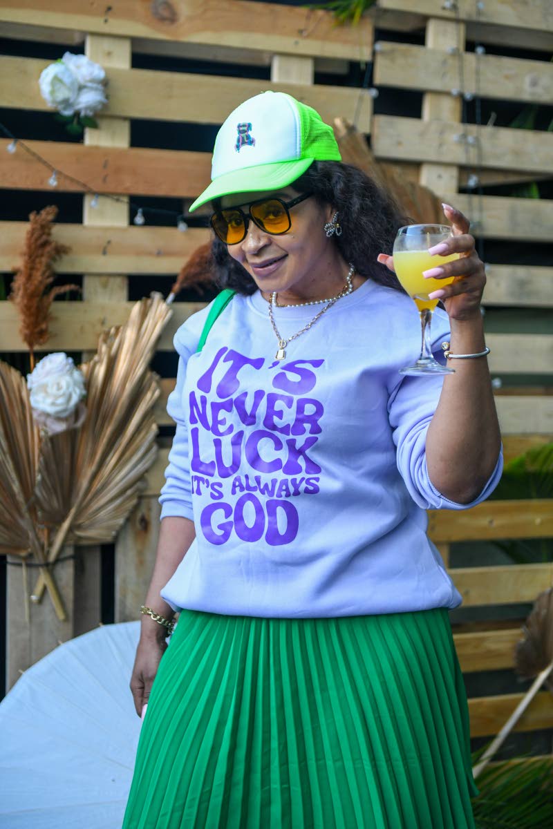 In a green pleated skirt, sweat shirt and a cap to match, Anneta Mattocks raises her glass in a toast. 