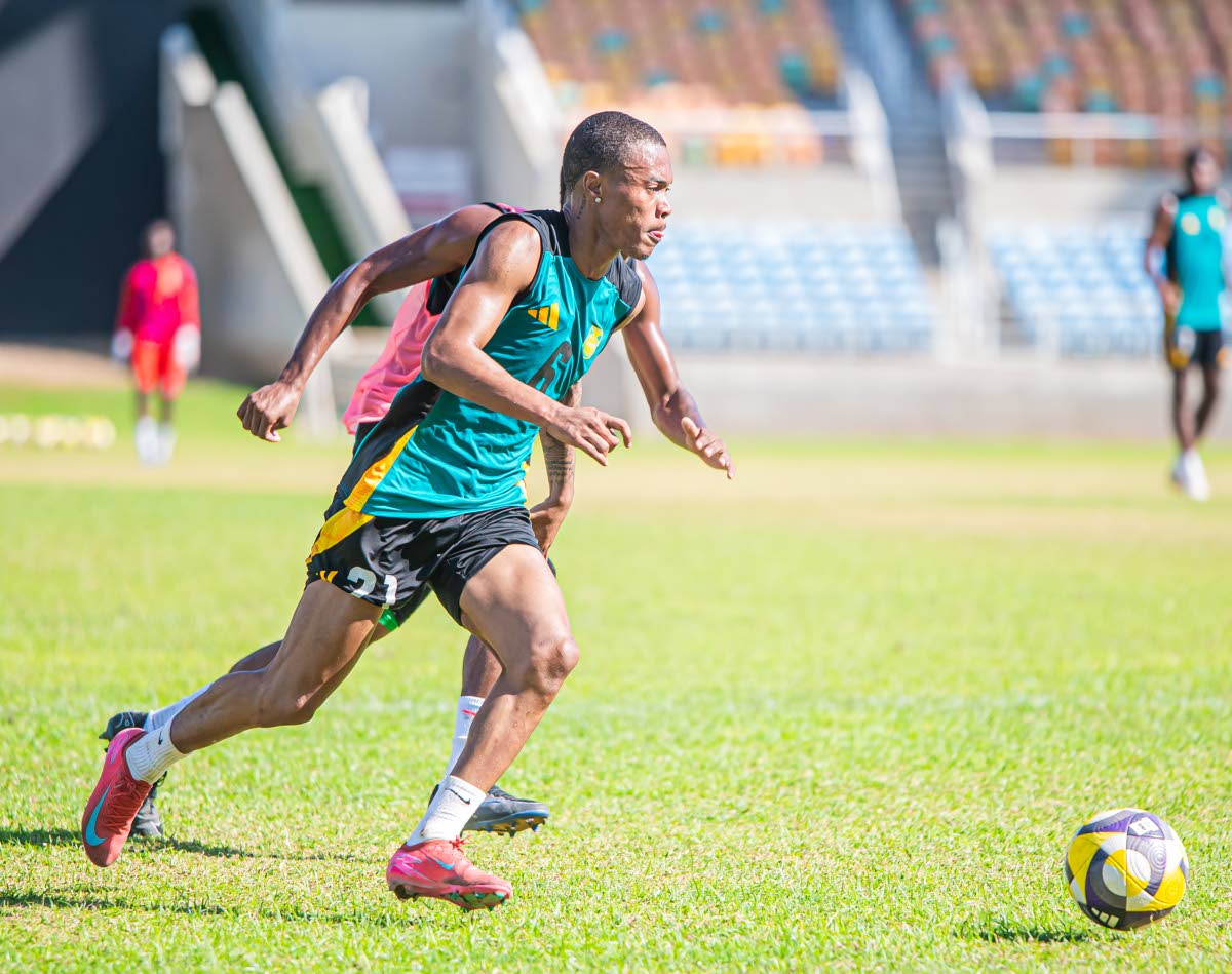 Reggae Boy Deshane Beckford dribbles way from his marker during a training session at Sabina Park. The Reggae Boyz were preparing for today’s encounter against Grenada.