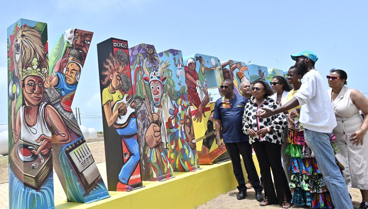 Jamaican artist Matthew McCarthy (second right) explains the mural to (from left) Mayor of Kingston Andrew Swaby; Audley Deidrick, president and CEO of Airports Authority of Jamaica; Olivia Grange, minister of culture, gender, enterainment and sport; Odett