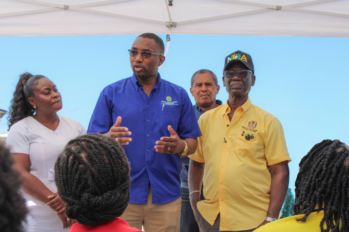 Minister of Local Government and Community Development, Desmond McKenzie (right), listens as Executive Director of the Social Development Commission, Omar Frith (second left), addresses staff of the Trelawny Infirmary during a recent psychosocial interv