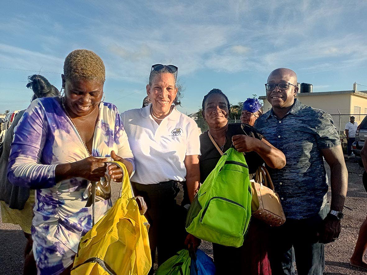 Colleen Wint-Bind (second left), project coordinator at the Violence Prevention Alliance (VPA), presents care packages to parents at Rocky Point in Clarendon at a community outreach activity organised by the VPA. Sharing in the moment is Pearnel Charles Jr