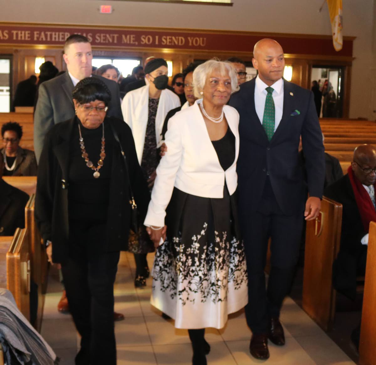 Governor of Maryland Wes Moore (right) escorts Sonia Ward, widow of Ambassador Curtis Ward, into the sanctuary of St Andrew Apostle Catholic Church in Silver Spring, Maryland, prior to the commencement of the thanksgiving service for the late Ambassador Wa