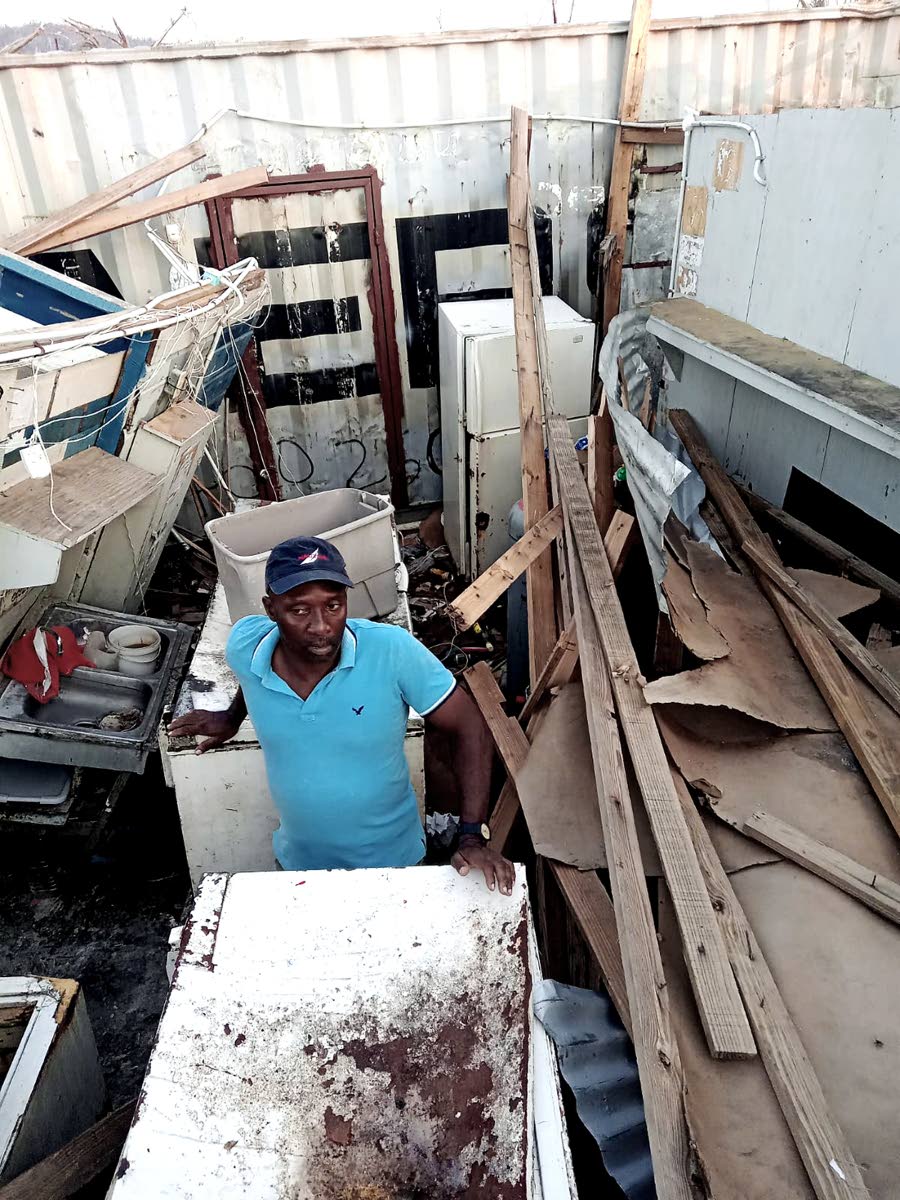 Delbert Rodney stands amid the devastation Hurricane Melissa wrought on his business.