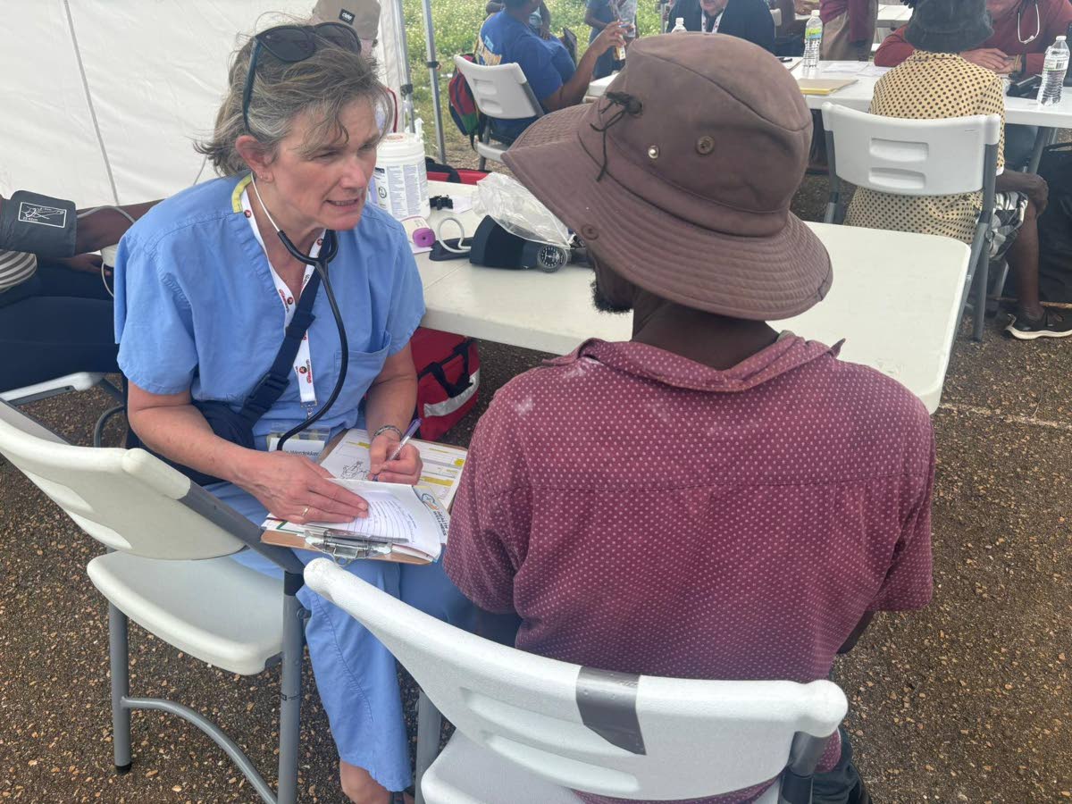 Ankie Wardekker (left), registered nurse with Team Broken Earth, attends to a community member during the organisation’s visit to McAlpine in Westmoreland on Wednesday.