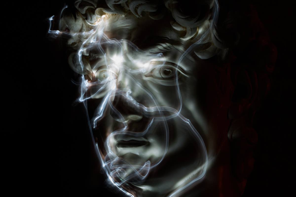 Stefania Terre, who is blind, uses a small light on her fingers while touching a life-size reproduction of the head of Michelangelo’s David as she poses for a long-exposure photograph.