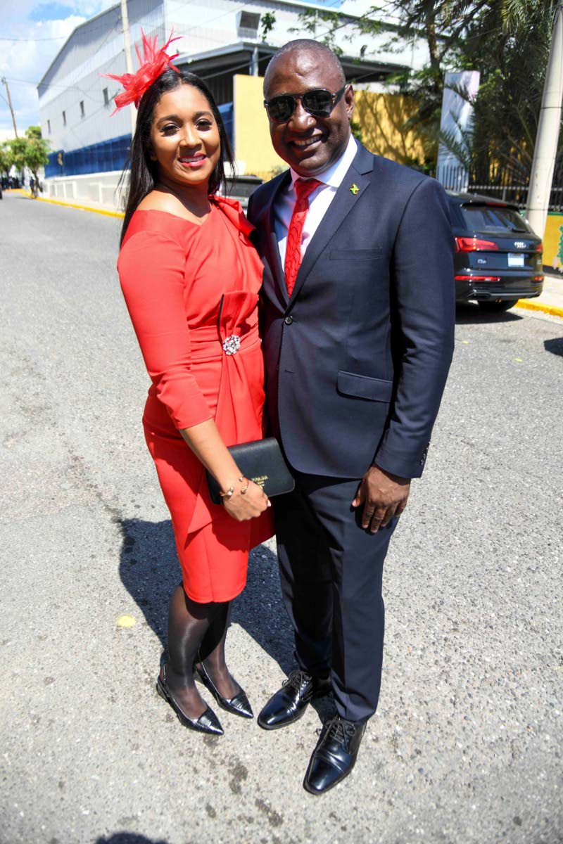 In complementary red, Dr Dayton Campbell, member of parliament for Westmoreland Eastern, suits up for the occasion in a MaxBrown International original, while Shaydia Sirjue, stuns in a Missacc dress and matching fascinator.  
