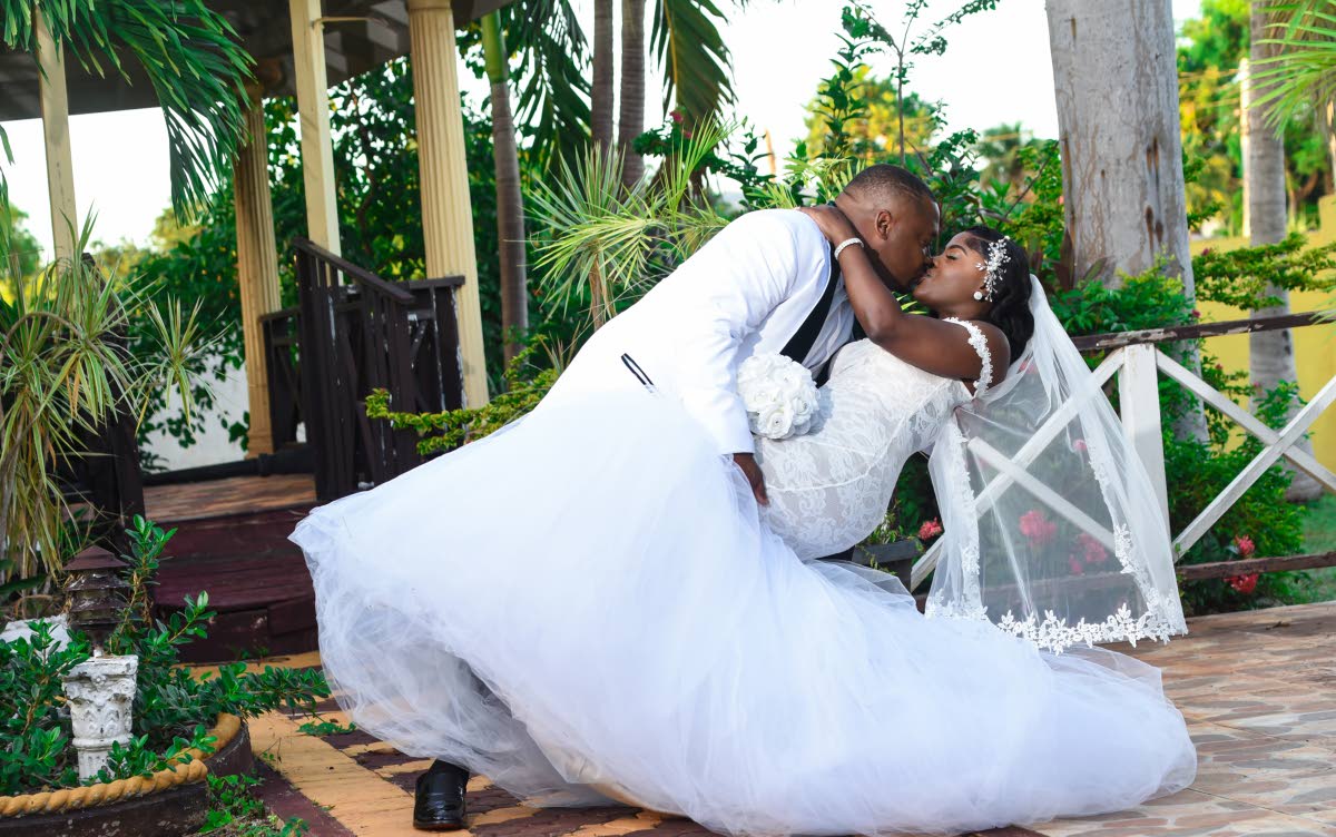 Glenroy sweeps his bride into a dip, sharing an enchanting kiss.