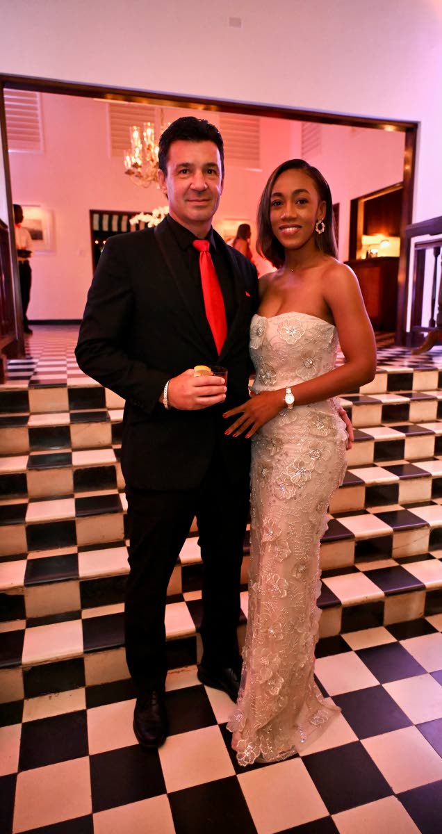 Richard Burrowes, president of Rosehall Development, wears Perry Ellis as he poses with partner, Sareika Jamieson, in a Revolve gown. 