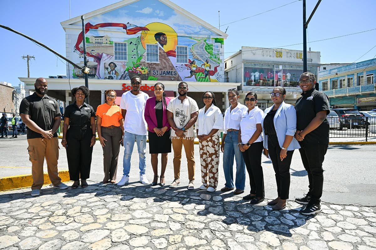 Executives from Kingston Creative, Target 8.9 and the Montego Bay Cultural Centre join Montego Bay Mayor Richard Vernon (centre), Minister of State in the Ministry of Tourism Tova Hamilton (fifth right), and western artists in front of the mural "Echoes of
