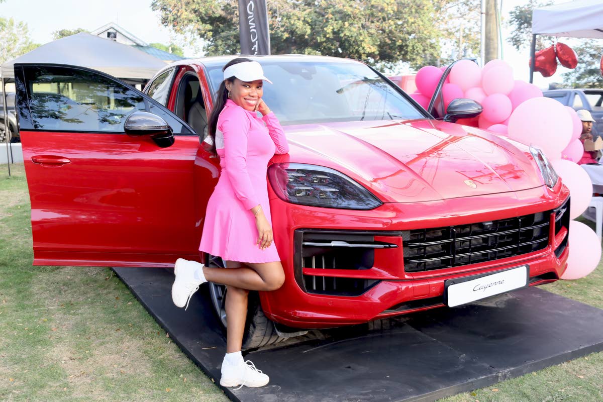  Anika Lake Francis, founder of the Jamaican Women’s Golf Network, strikes a playful pose next to a 2024 Porsche Cayenne.