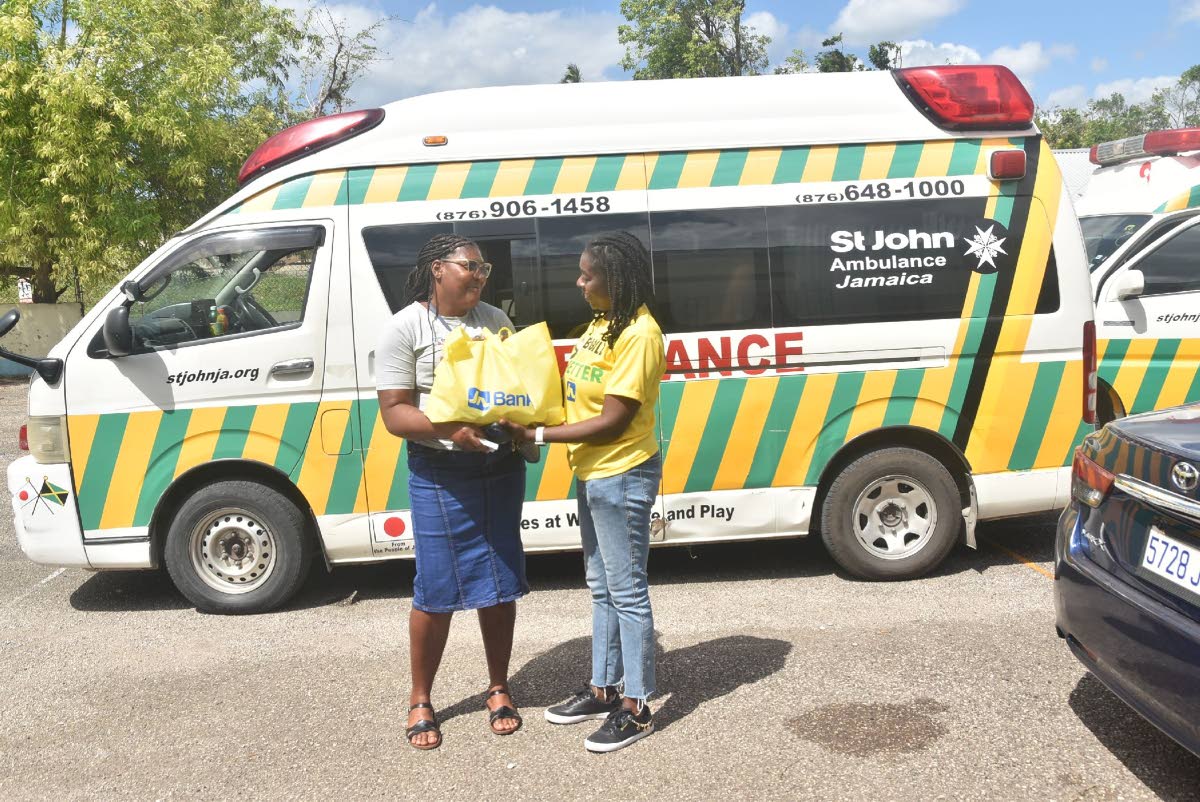 Dawnette Pryce-Thompson (right), project coordinator at JN Foundation, presents a care package to a member of the Balaclava community in St Elizabeth. Occasion was a medical mission organised by the JN Foundation, in collaboration with St John Ambulance. T
