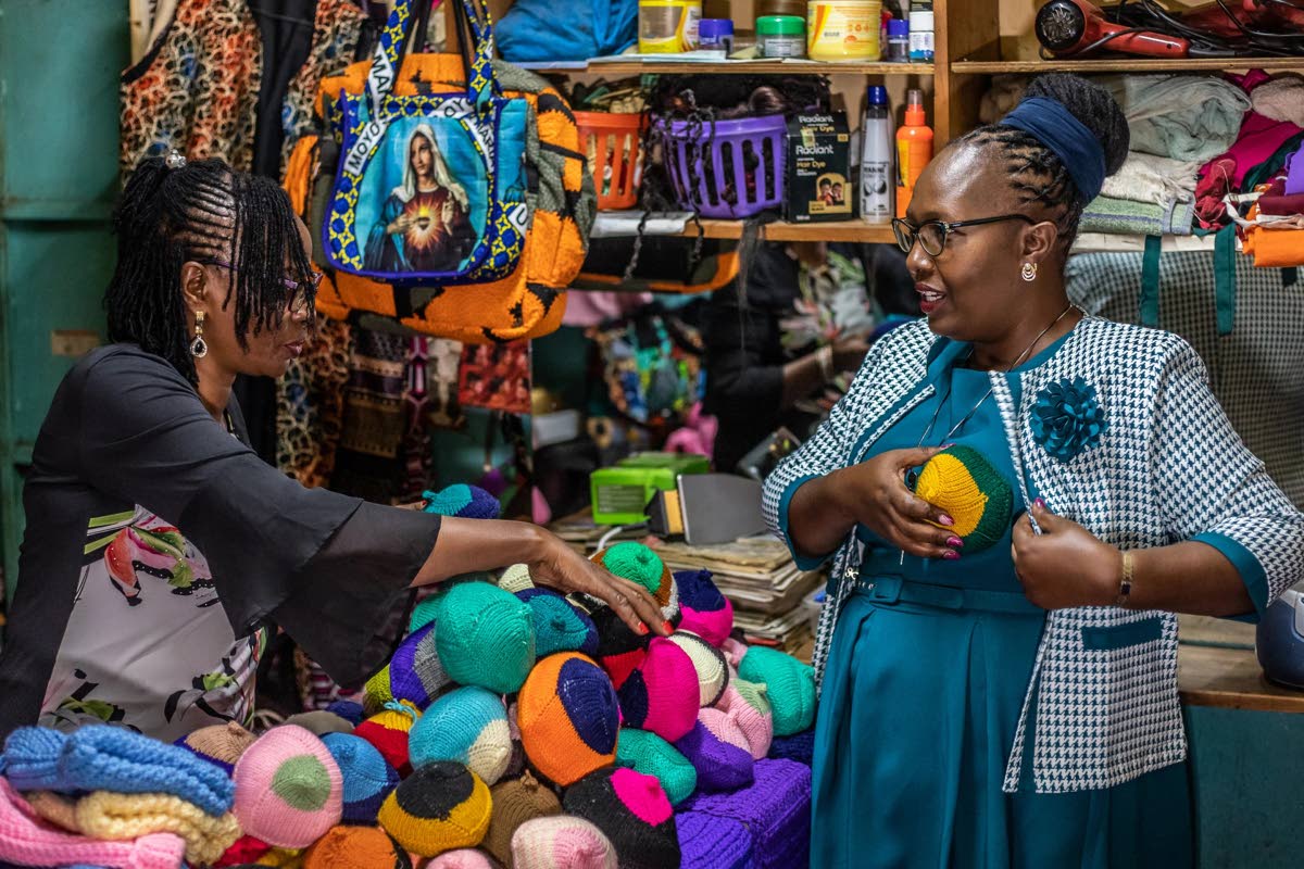 Nancy Waithera (right) tries on a knitted breast prosthesis as Mary Mwangi, 52, looks on at her shop in Thika, Kiambu County, Kenya, January 30.