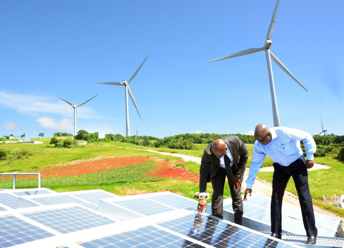Then Energy Minister Dr Andrew Wheatley (left) and then Wigton Windfarm Chairman Duane Smith examine solar panels at the wind farm in Manchester on November 2, 2016.