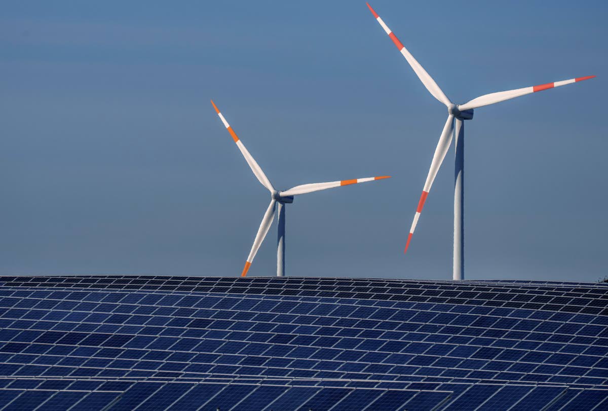 Wind turbines turn behind a solar farm in Rapshagen, Germany.  AP 