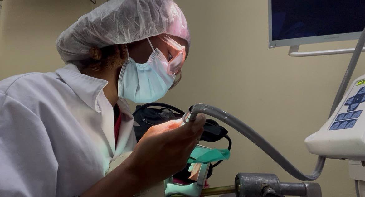 Jade Cohall-Cunningham demonstrates cavity preparation and restoration on a dental mannequin during her clinical practice.