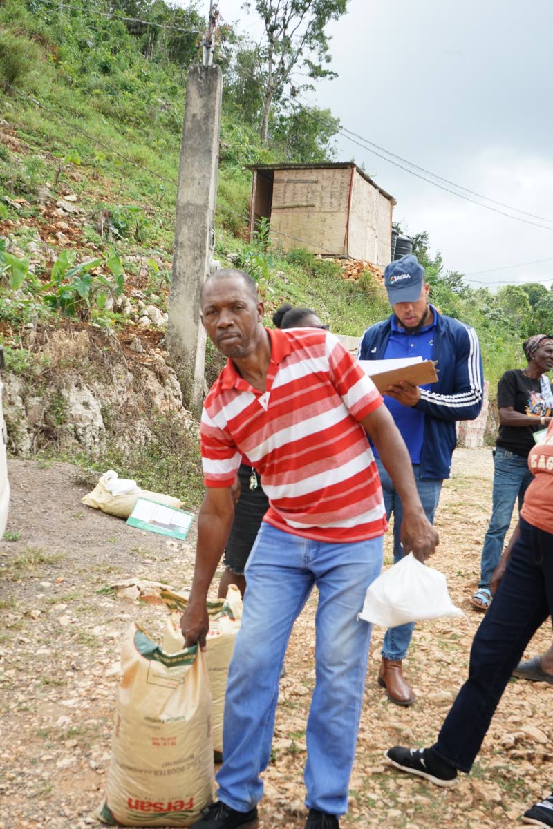 Ginger farmer Glenroy Green carries items from the chemical input package he received following the rhizome rot training session in Grant’s Bailey, St Ann.