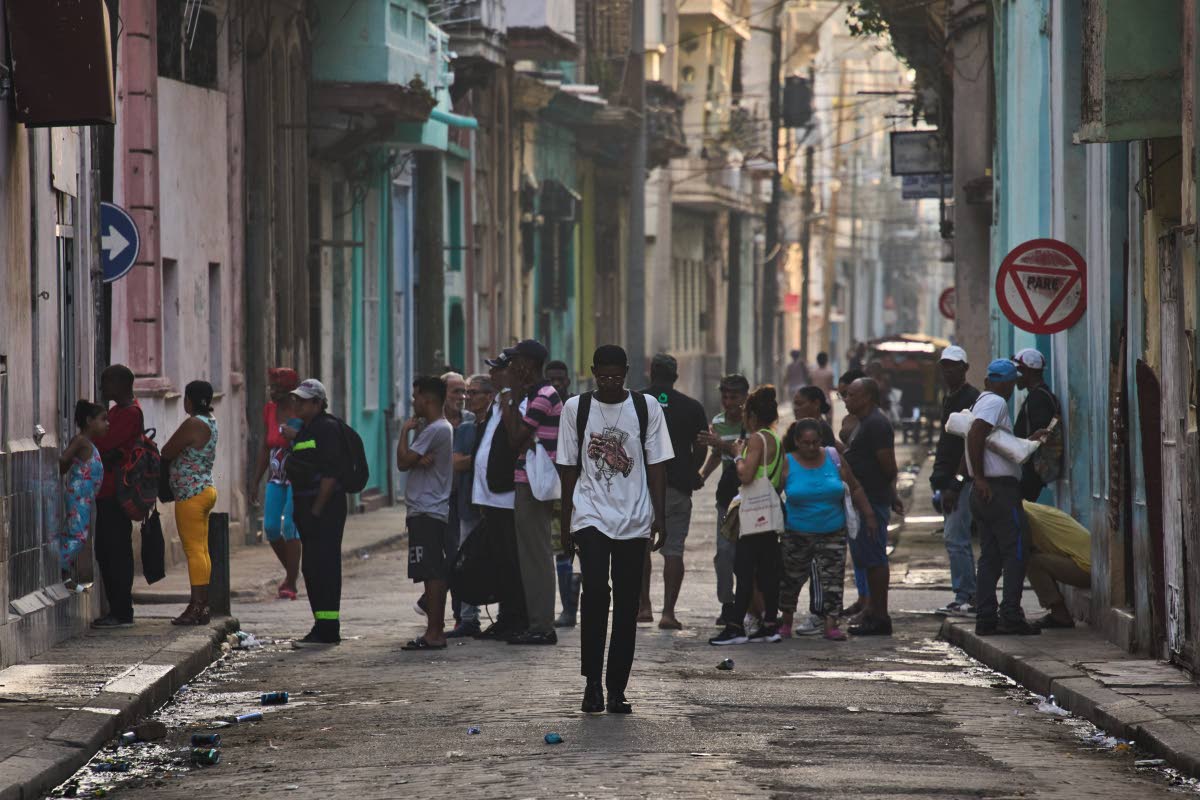People line up in the street to buy bread in Havana, Cuba, Friday, March 13, 2026. 