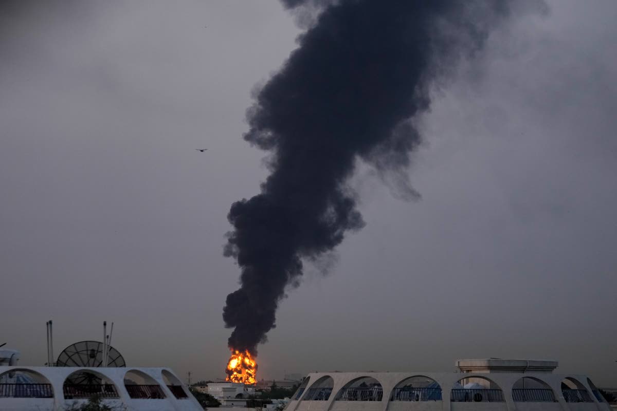 Fire and plumes of smoke rise after a drone struck a fuel tank forcing the temporary suspension of flights. near Dubai International Airport, in United Arab Emirates, early Monday, March 16.