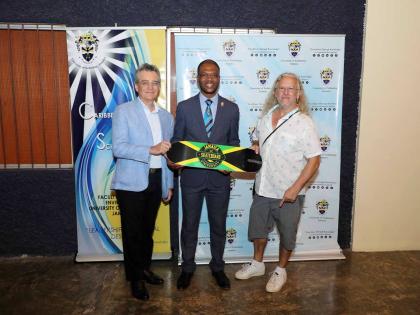 Remy Walter (right), founder, Jamaica Skate Culture Foundation, presents Dr Kevin Brown (centre), president, University of Technology, Jamaica, with a Skate Culture branded skateboard on August 7, inside the Alfred Sangster Auditorium. Participating in the