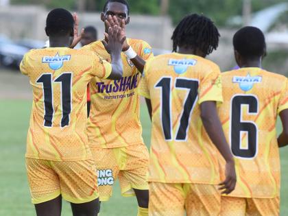 Members of Garvey Maceo High’s daCosta Cup football team celebrate after scoring against Foga Road High on the opening day of the competition at the Stadium East field last Saturday.