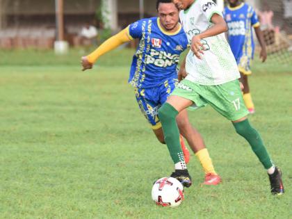 Frome Technical High School’s Raheem Dennison (right) tries to outrun Cambridge High School’s Kiron Malcolm during their Zone B ISSA daCosta Cup game at Jarrett Park on Saturday.
