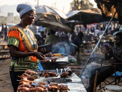 A woman buys food from a street vendor in Zomba, Malawi.