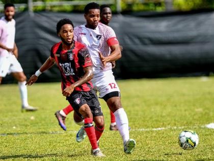 Jamone Anthony (left) of Arnett Gardens and Andrew Vanzie of Chapelton Maroons battle for possession during their Jamaica Premier League football match at Turner’s Oval in Chapelton, Clarendon, yesterday. Arnett won 1-0.