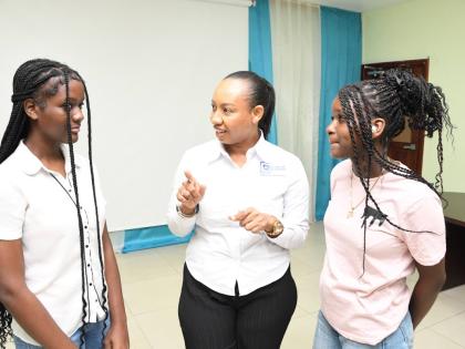 Sydoney Preddie (centre), lead – youth and education programmes, JN Foundation, in discussion with Taeja Stoney (left) and Reneicia Hall, students who participated in the JN Financial Academy Summer Camp.
