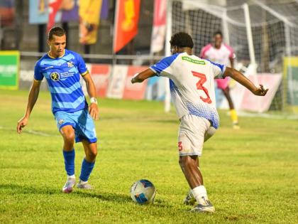 Dunbeholden’s Ricardo Beckford (right) tries to dribble by Molynes United’s Leyvan Rigg during their Jamaica Premier League encounter at the Waterhouse Stadium yesterday. Dunbeholden won 2-0. 