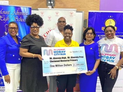 Principal of Mount Alvernia High, Kayon Whyne (second left) and Centennial Committee Chairman Marline Stephenson Dalley (left), accept a symbolic $1-million cheque from the Jill Stewart MoBay City Run in support of centennial projects at Mount Alvernia Hig