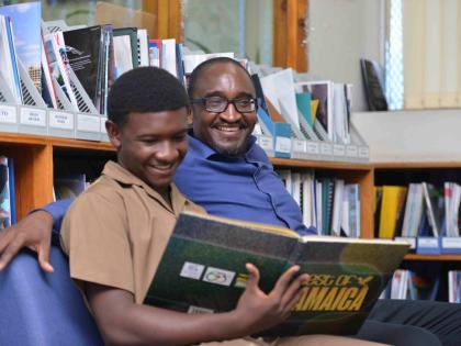 Fifteen-year-old Joshuah Channer of Wolmers Boys’ School, who aced three Caribbean Secondary Education Certificate subjects in fourth form, and dad Dr Guyan Channer.