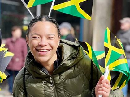 Mica Moore waves Jamaican flags after securing her Jamaican citizenship.