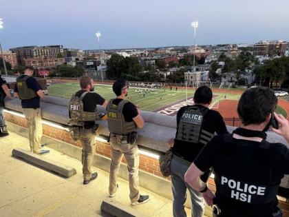 Officers from Metropolitan Police Department, FBI, and Homeland Security Investigations (HSI) are seen monitoring a football game between Bell Multicultural and Archbishop Carroll on September 12, at Cardozo High School in the Columbia Heights neighbourhoo