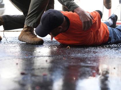 A man is detained by immigration agents at a car wash on Friday, August 15, in Montebello, California. 