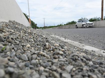 A car left disabled near Grants Pen, St Thomas, after it crashed in the barrier after skidding in gravel left along the roadway by trucks transporting aggregate.