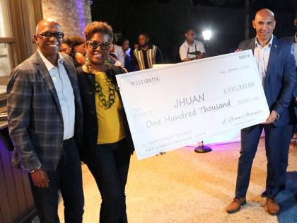 Jamaica’s ambassador to the United States, Major General (Ret’d) Antony Anderson (right), receives a cheque for US$100,000 from Lisa Brown Alexander (second left), a Howard alum and owner of Wellspring Manor & Spa in Upper Marlboro, Maryland, on behalf