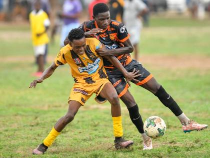 Jerome Clarke (left) of Haile Selassie High tries to keep the ball from Jahiem Fuller of Tivoli High during their Manning Cup match on Thursday at Tivoli. The game ended in a 2-2 draw. 