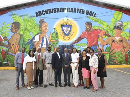 Samantha Charles (third right), CEO of the VM Foundation, leads members of the VM team and the Holy Trinity High School faculty in a photo opportunity following the official handover of a legacy mural (in the background) to the school on September 16. It i