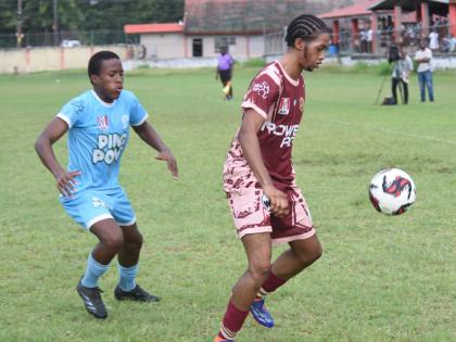 Herbert Morrison Technical High School's Amere Brown (right) shields the ball from Maldon High's Alikay McFarlane during their ISSA daCosta Cup Zone A football match at the Herbert Morrison High play field yesterday. Herbert Morrison won 1-0.