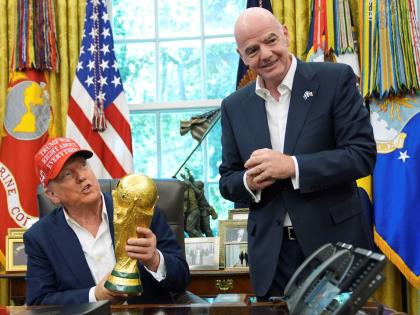 President Donald Trump holds the FIFA World Cup Winners Trophy as FIFA President Gianni Infantino looks on during an announcement in the Oval Office of the White House, August 22, 2025, in Washington. (AP Photo/Jacquelyn Martin, File)