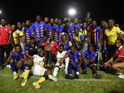 Members of the RJRGLEANER team celebrate winning the KSAFA Business House Division One football title with their fans at Ashenheim Stadium, Jamaica College, on October 4.