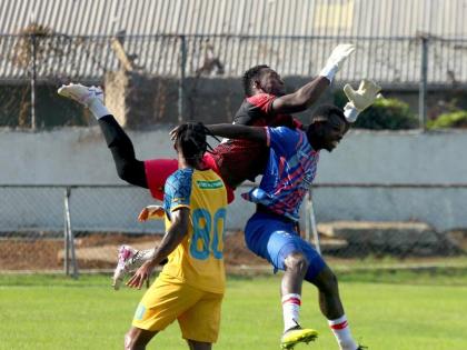 Racing United goalkeeper Aaron Enill jumps to intercept a cross ahead of Portmore United striker Peter McGregor at Ferdi Neita Sports Complex yesterday. Looking on is Jevon Bascow.