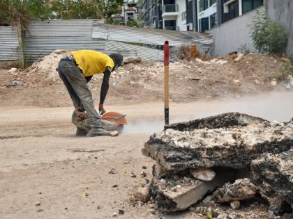 In this August photo, a worker is seen cutting the surface of a road on Wellington Drive where NWA was laying pipelines.