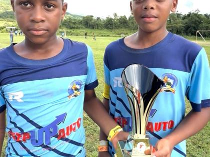 Jasean Anderson (left) and Aamir Witter, co-captains of El Instituto de Mandevilla, display the Youth Football League Junior Cup Under-11 Rural Competition trophy they won at the Kirkvine Sports Complex in Mandeville on Saturday.  