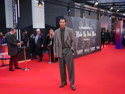 Daryl McCormack styles his Emporio Armani grey double-breasted suit with a polka dot tie. 